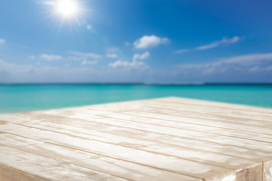 Empty table with clean copy space for product placement set in front of exotic sea. The background of  turquoise sea water and  bright tropical atmosphere, creating relaxing spa and zen mood.