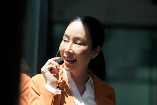 Asian businesswoman speaking into lavalier microphone