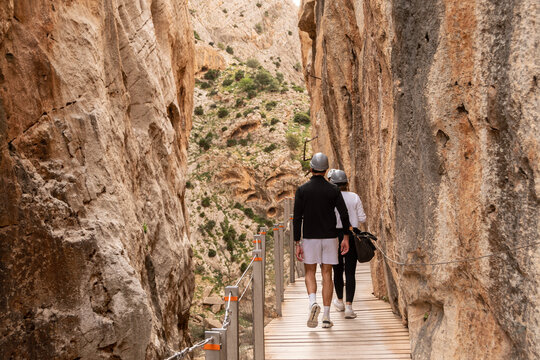 Pareja caminando por el Caminito del Rey entre paredes rocosas
