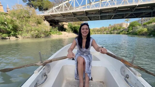 Latin woman paddling canoe on Segura River in Murcia, Spain, smiling and enjoying summer afternoon, travel lifestyle and freedom concept