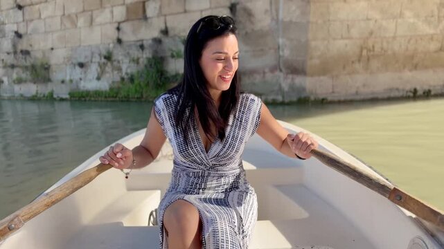 Latin woman paddling canoe on Segura River in Murcia, Spain, smiling and enjoying summer afternoon, travel lifestyle and freedom concept