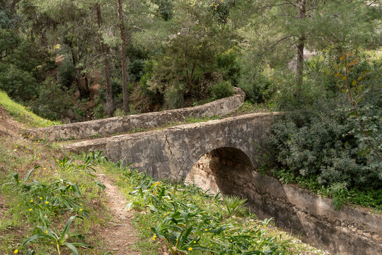 Puente de piedra sobre acequia en entorno natural en M&aacute;laga