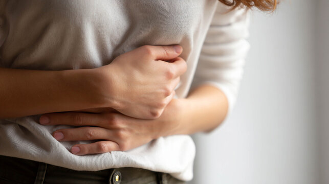 Young woman touching right abdomen under ribs, gallstone pain concept