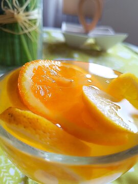 Lemon slices in orange juice with ice cubes in the glass fresh citrus fruit summer background