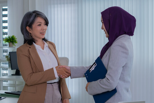Muslim female applicant consulting with hiring manager in modern