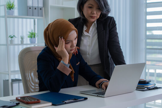 Muslim female applicant consulting with hiring manager in modern