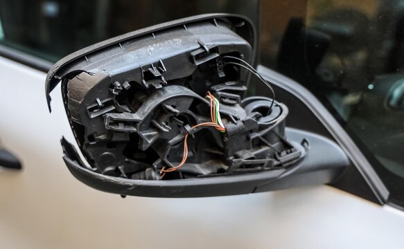 Damaged car side mirror showing exposed wiring