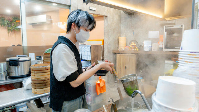 Chef in a Taiwanese restaurant preparing dish