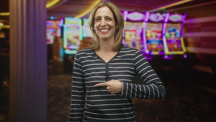 Fototapeta premium Woman smiling and giving thumbs up in front of brightly lit slot machines inside a casino building; winning joy.