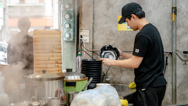 Washing dishes in a bustling Taiwanese restaurant kitchen