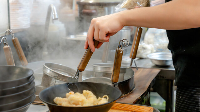 Chef preparing Taiwanese cuisine in restaurant kitchen