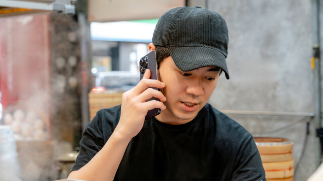 Chef speaking on phone in Taiwanese restaurant kitchen
