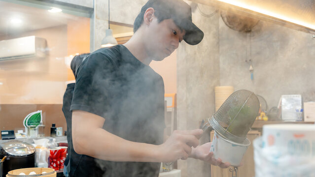 Taiwanese chef at work in a busy kitchen setting