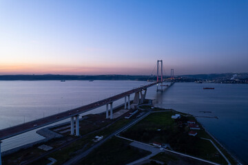 Fototapeta premium Osmangazi Bridge in Kocaeli, Turkey. Aerial shot with drone. Beautiful sunset landscape.