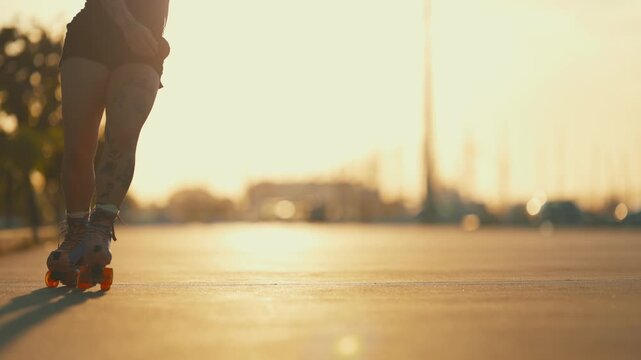 Silhouette of a young woman rollerskating during a beautiful golden sunset