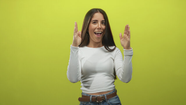 Woman pinching fingers to show a tiny amount while wearing a white long sleeve top and jeans in studio; skepticism measurement.