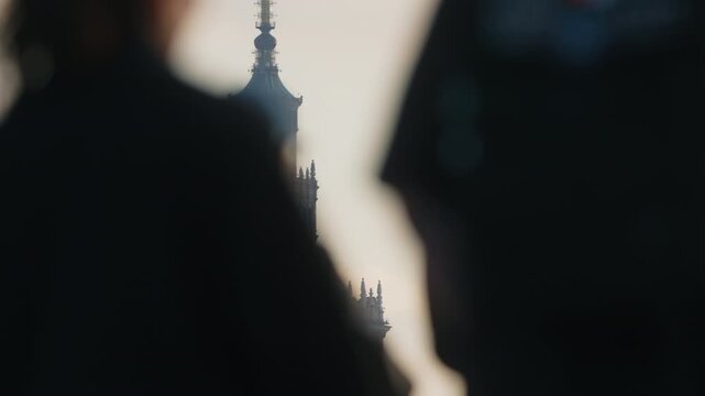 City skyline with soft warm light golden hour, blurred silhouettes of pedestrians and cyclists on bridge, modern glass skyscrapers and iconic clock tower in background, spring urban scene