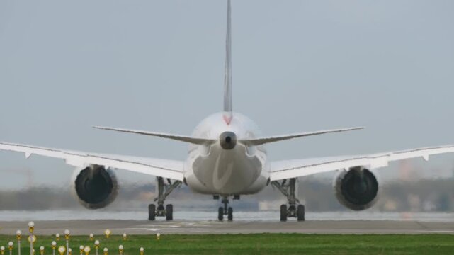 White passenger aircraft accelerating on runway during takeoff roll, rear close up with engines at full thrust in hot sunny conditions, intensified heat haze distortion, slow motion aviation scene