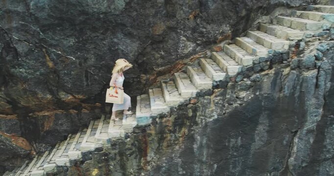 Woman in Hat on Stone Steps at Sa Calobra Beach Mallorca
