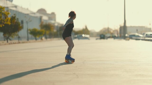Young tattooed woman roller skating at sunset