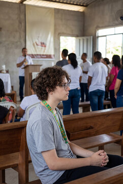 Young man with curly hair attending church servi