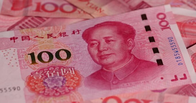 red Chinese money in denominations of one hundred yuan and American dollars , a pile of paper cash of American and Chinese money , Chinese banknotes of 100 yuan