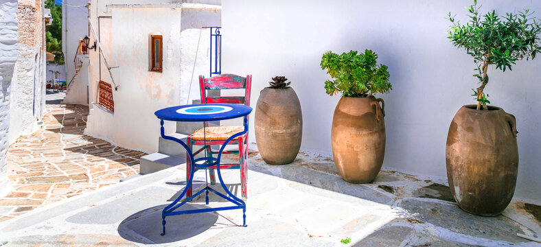 Lefkes Paros Greece, Traditional Village Narrow Street with Blue Chairs and Round Table, Ancient Clay Amphora Vases on White Walls, Authentic Cycladic Mediterranean Aesthetics Summer Travel