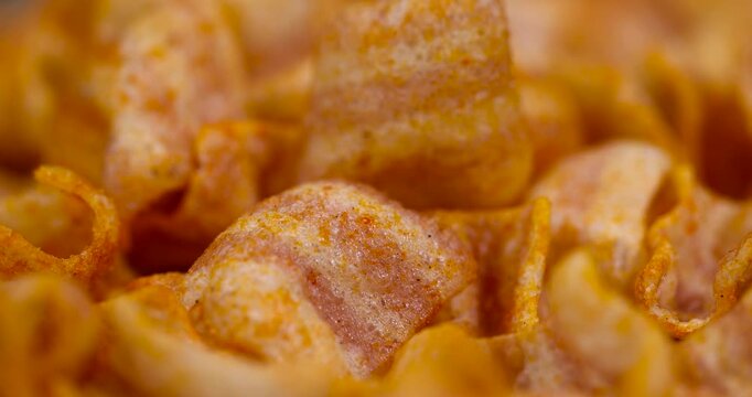 crispy mashed potato chips fried in a large amount of sunflower oil, sprinkled with red hot spices, crispy delicious high-calorie chips with spices are scattered on the table