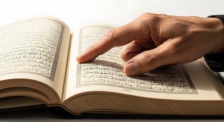 Fototapeta premium Finger pointing at text in open book with soft lighting and copy space