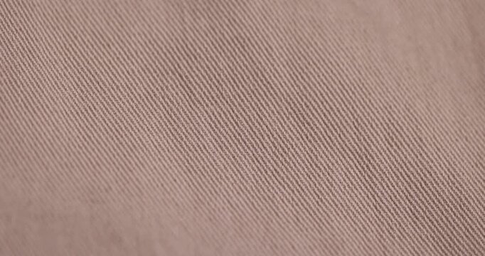 a new thin beige fabric from trousers, details of the beige fabric from which trousers or other clothes are sewn