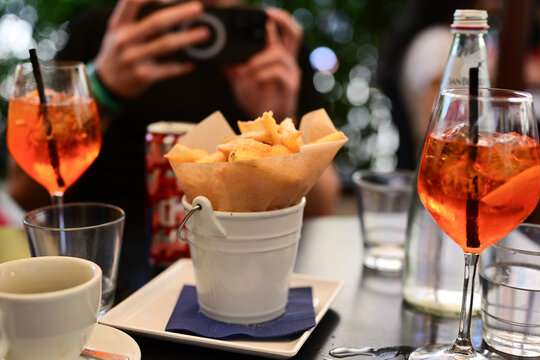   Aperol Spritz  andf french fries, tipical italian snack for aperitivo in a bar in Rome, Italy