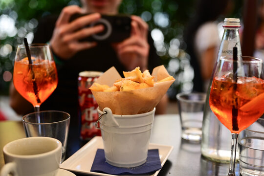   Aperol Spritz  andf french fries, tipical italian snack for aperitivo in a bar in Rome, Italy