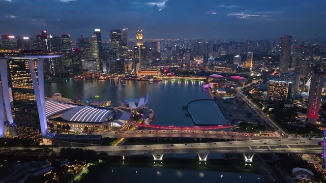 Real time aerial video of Sunset in Singapore City Skyline. Flying Towards Marina Bay Sands and Gardens In Singapore. View of modern hotels and financial buildings. Travel landmark, tourist attraction