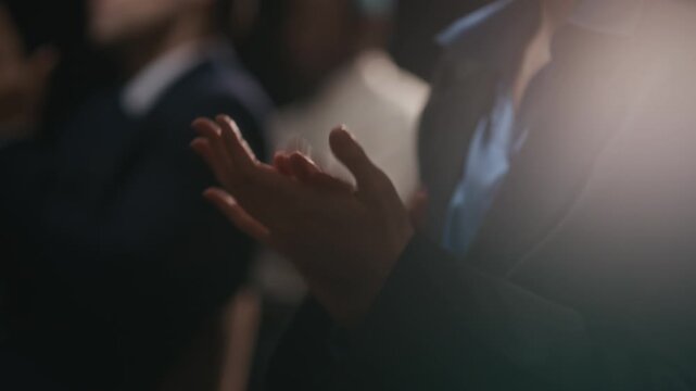 Handheld cropped closeup shot of hands of unrecognizable businessmen wearing suit clapping hands after presentation at conference