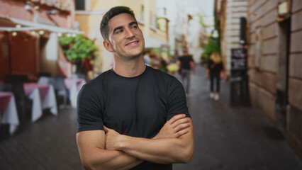 Obraz premium Man with arms crossed on street terrace outside restaurant, smiling and looking up; contentment casual confidence.