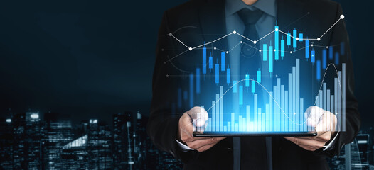 A business professional stands against a city skyline, holding a tablet displaying dynamic financial charts, representing data analysis and market trends. Scalp © InfiniteFlow