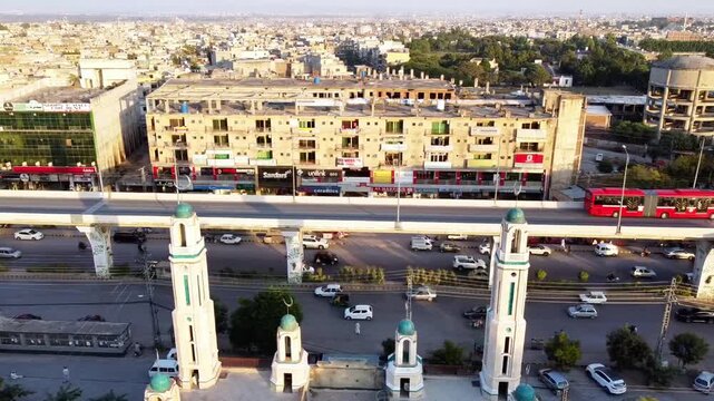 Aerial View of Metro Bus Elevated Track and City Skyline Over Mosque Minarets in Pakistan