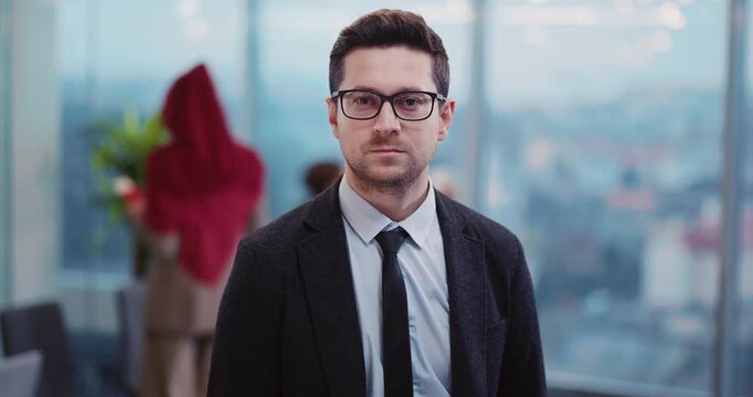 Portrait of Handsome Bearded Young Entrepreneur Wearing Glasses Looking into Camera while Waiting in Terminal Aiport Lounge Departure.