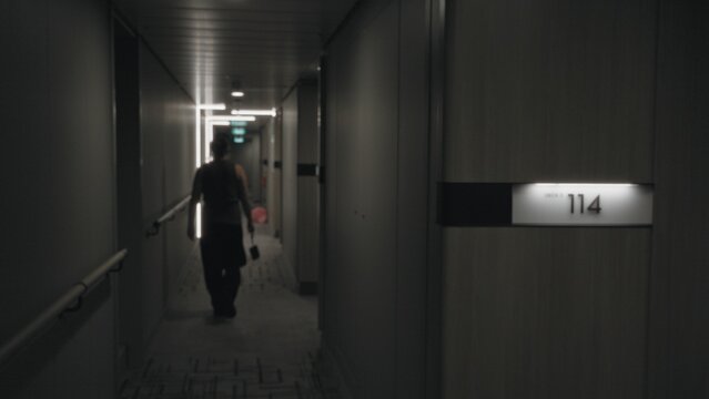 Defocused hotel corridor with soft bokeh lighting, illuminated room signage and handrails; background backplate copyspace calm.