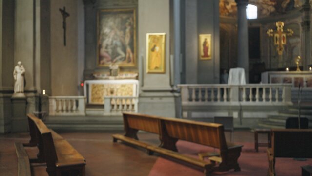 Interior church nave with soft defocused bokeh and shallow focus on wooden pews, altar and stone columns; background backplate copyspace calm.