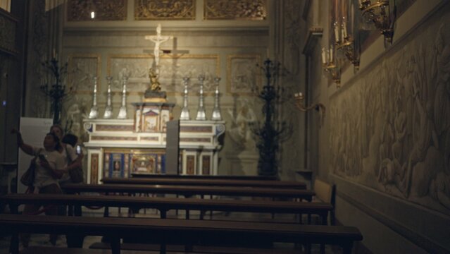 Defocused church interior showing a blurred altar, wooden pews and carved wall relief in soft shallow bokeh background; background backplate copyspace calm.