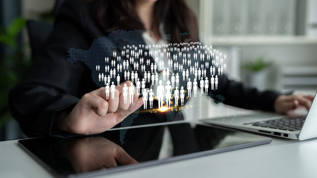 Business professional interacts with digital population map, symbolizing networking and global connections in a modern workspace setting Quark.
