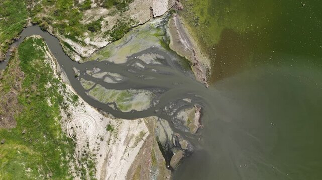 An aerial drone view of the delta formed by a river flowing into Lake Burdur. A natural landscape highlighting water pollution and environmental issues.
