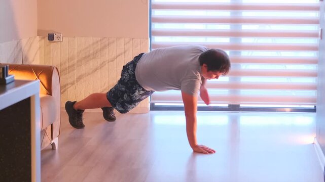Man performs plank chest taps on a mat at home, training core stability, balance and strength. Bodyweight fitness exercise for abs and endurance in indoor workout routine