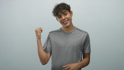 Boy smiling and beckoning with hands in a studio gray tshirt, wearing thin necklace and earring;...