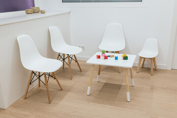 Fototapeta premium Waiting room with toys on a table and white chairs