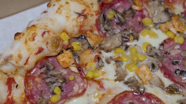 pizza slice macro with salami cheese corn and mushrooms, baked crust detail and toppings texture