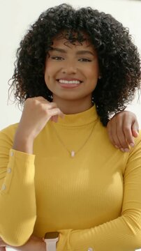 Vertical video: Smiling woman in yellow top feeling hand on shoulder in studio with chain and watch