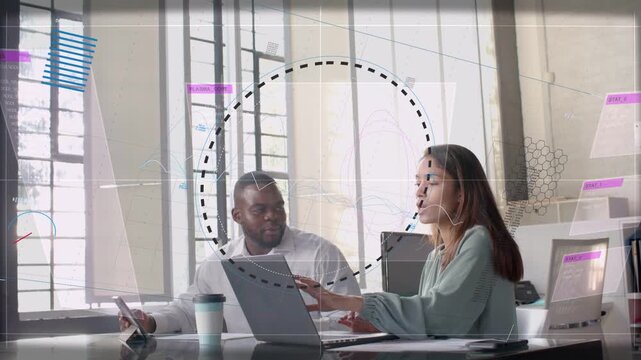 Man pointing at laptop and woman typing, animated charts expanding around them for business review