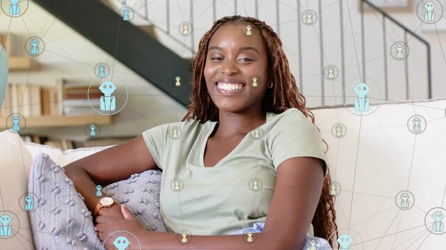 Woman on sofa smile widening causing blue gold humanoid icons circling face, showcasing tech